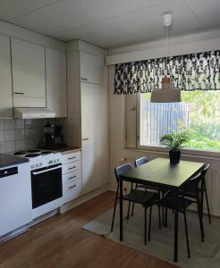 a kitchen with a table and chairs and a window at Honkatilat majoitus as 2 in Kajaani