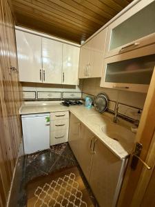 a small kitchen with white cabinets and a sink at Konçoğlu Pansiyon in Uzungöl