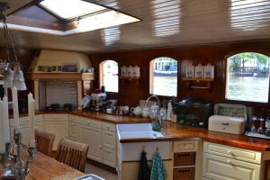 Una cocina con gabinetes blancos y encimera. en art deco houseboat on super location, en Ámsterdam 21 fotos más