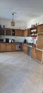 a large kitchen with wooden cabinets and a tile floor at Ela apartament in Golem