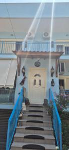 a stairway leading to a white door with blue railing at Ela apartament in Golem