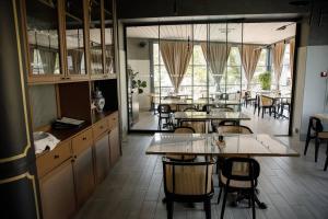 a dining room with tables and chairs and windows at R.HOTEL in Chernivtsi