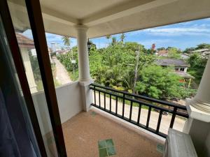 a balcony with a view of a street and trees at Klong Muang Hostel คลองม่วงโฮสเทล in Ban Ko Kwang