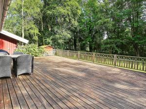 a wooden deck with two chairs and a fence at 4 person holiday home in Vejby in Vejby