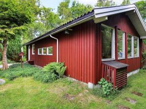 a red tiny house with a large window at 4 person holiday home in Vejby in Vejby