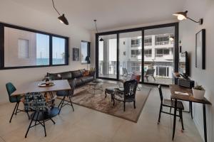 a living room with a couch and a table and chairs at Renoma in Tel Aviv