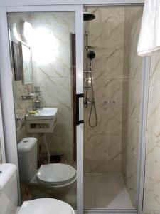 a bathroom with a shower and a toilet and a sink at YAN N' VI HOMe in Abidjan