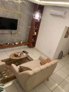 a living room with a couch and a tv at YAN N' VI HOMe in Abidjan