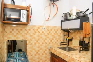 a kitchen with a sink and a microwave at YAN N' VI HOMe in Abidjan