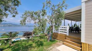 a house with a deck with a view of the water at Camping La Rocca in Manerba del Garda
