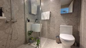 a bathroom with a toilet and a shower at Ansan Minimal Studio in Ansan