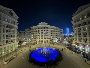 a large fountain in the middle of a city at night at BOULEVARD apartments in Tashkent