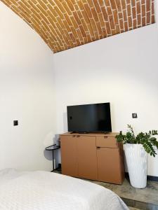 a bedroom with a bed and a tv on a dresser at DMR APARTMENTS Central in Košice