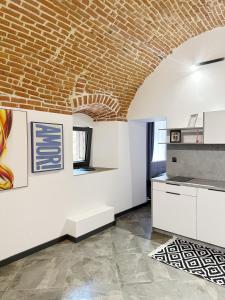 a kitchen with a brick ceiling and white cabinets at DMR APARTMENTS Central in Košice