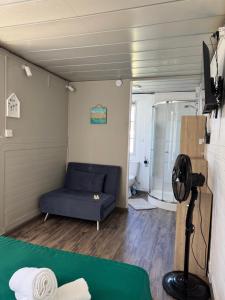 a living room with a blue couch and a shower at Tikaban in Pointe d'Esny