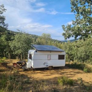 a white trailer parked in the middle of a field at CAMPING Pleine Nature in Boule - dÊ¼Amont