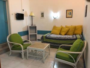 a room with a bed and two chairs and a table at Sabina villa in Pereybere