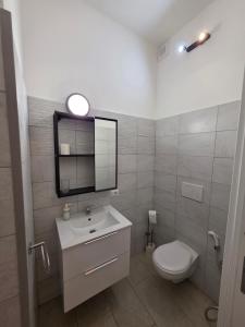 a bathroom with a toilet and a sink and a mirror at Alloggio turistico di Stefano in Lido di Ostia