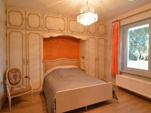 a bedroom with a bed and a chandelier and a window at Stay in Stavelot, Liege in Stavelot