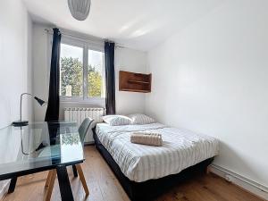 a small bedroom with a bed and a glass table at Le Cosy Genin - 3 Chambres Bureaux Parking in Lyon