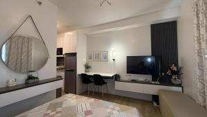 a living room with a large mirror and a television at JPD Mesavirre Garden Residences in Bacolod