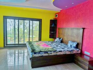 a bedroom with a bed with a colorful wall at The Secret Villa in Panchgani
