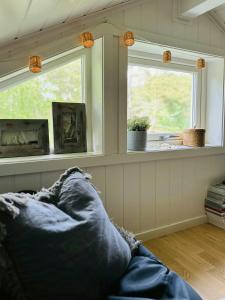 a living room with a couch and two windows at Modern Cabin With A Short Walk To The Sea in Skjærhollen +24 photos