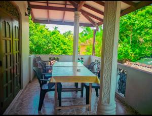 - une terrasse couverte avec une table et des chaises dans l'établissement ANINA resort mirissa, à Mirissa