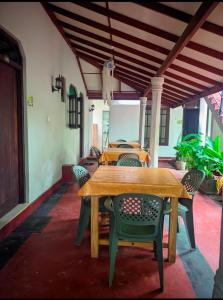 une table et des chaises en bois sur une terrasse dans l'établissement ANINA resort mirissa, à Mirissa
