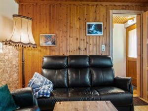 a living room with a leather couch and a table at Chalet in Eberstein nahe Saualpe Skigebiet in Eberstein