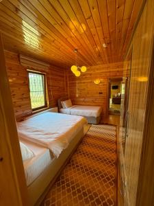 a bedroom with two beds in a wooden cabin at Konçoğlu Pansiyon in Uzungöl