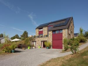 a brick house with a red garage at Cozy Nature Escape, Stoumont in Stoumont