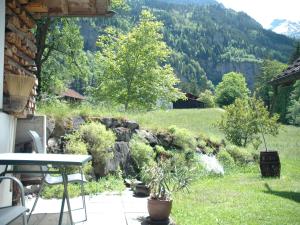 ein Garten mit einem Tisch und einer Steinmauer in der Unterkunft Nature Escape in Kander Valley in Kandergrund + 28 Fotos