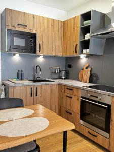 a kitchen with wooden cabinets and a wooden table at Apartmán Mácháč in Doksy