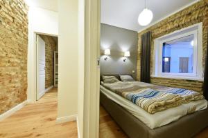 un grande letto in una stanza con un muro di mattoni di Domillion 3bdr 2baths President Palace park L419A a Vilnius