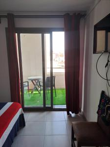 a room with a door open to a patio with a table at SaintGermain in Aïn El Turk +7 photos