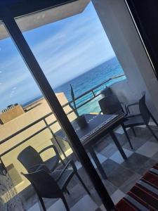 a view of the ocean from a balcony with a table and chairs at SaintGermain in Aïn El Turk