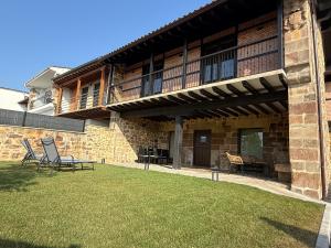 a building with two chairs on a lawn at Zurita Rural Suites in Zurita +36 photos
