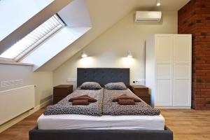a bedroom with a large bed in a attic at Domillion New modern Vilnius old town studio U2302 in Vilnius
