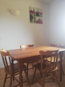 a wooden table with four chairs around it at Studio chaleureux de montagne in Ustou
