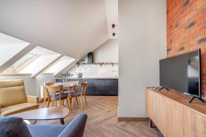 un salon avec une télévision et une salle à manger dans l'établissement Domillion 1bdr New Old Town apt U2306, à Vilnius