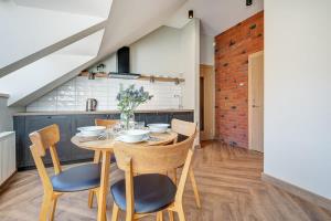 Un comedor con mesa y sillas de madera. en Domillion 1bdr New old town apt U2307, en Vilna