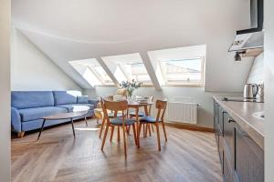 a living room with a table and a blue couch at Domillion 1bdr New old town apt U2308 in Vilnius