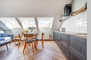 a kitchen and dining room with a table and chairs at Domillion 1bdr New old town apt U2308 in Vilnius