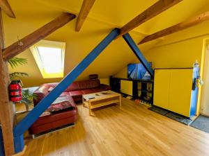 a living room with yellow walls and wooden beams at Anton's bunte Welt (100 m², Parkplatz, Garten und viel mehr) in Albersdorf