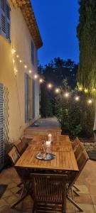 a wooden table and chairs on a patio at night at Bargemon villa with modern interior and gorgeous view - with private pool and aircon in Bargemon