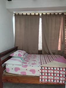 a bedroom with a bed and a window with avertisement at Hospedaje Bonanza in Santa Fe de Antioquia +3 photos