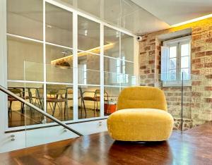 Sala de estar con silla amarilla y mesa en &Tales Hotel - Óbidos, en Óbidos 35 fotos más