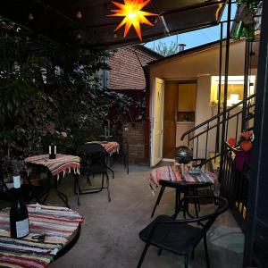 un patio avec des tables et des chaises et un lustre dans l'établissement Hotel 1870, à Koutaïssi