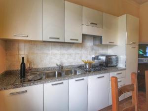 Una cocina con gabinetes blancos y un fregadero. en Serenity farmhouse in Castiglion Fiorentino, en Castiglion Fiorentino